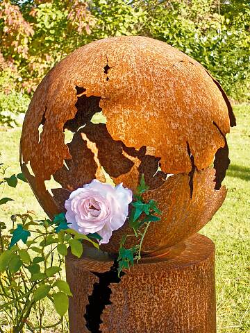 Die Gartenkugel kann im Stauden- oder Rosenbeet platziert werden. Wer mag, stellt einen Topf mit rankenden Sommerblumen hinein.