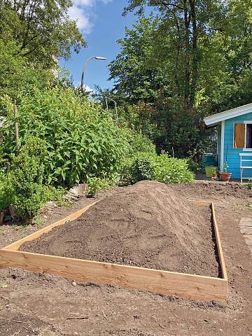 Ein Umrandung aus Holzbrettern, hier 20 cm hoch, kann auch im Nachhinein ergänzt werden. So hat man eine saubere, klare Kante und Abgrenzung.