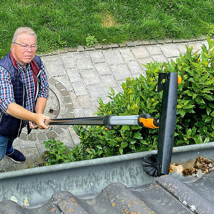 Mit dem Fiskars QuikFit-Dachrinnenreiniger und dem dazugehörigen Stiel können Sie bequem am Boden bleiben.